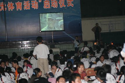 夜晚学校组织学生在运动场看电影